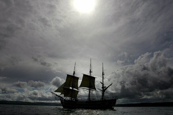 Schiff auf dem Hintergrund der dunklen Wolken