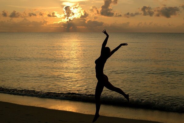 Ragazza sulla spiaggia sullo sfondo del tramonto