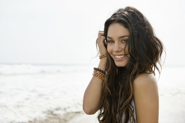 Bruna con i capelli lunghi, sullo sfondo dell oceano, con un braccialetto sul braccio