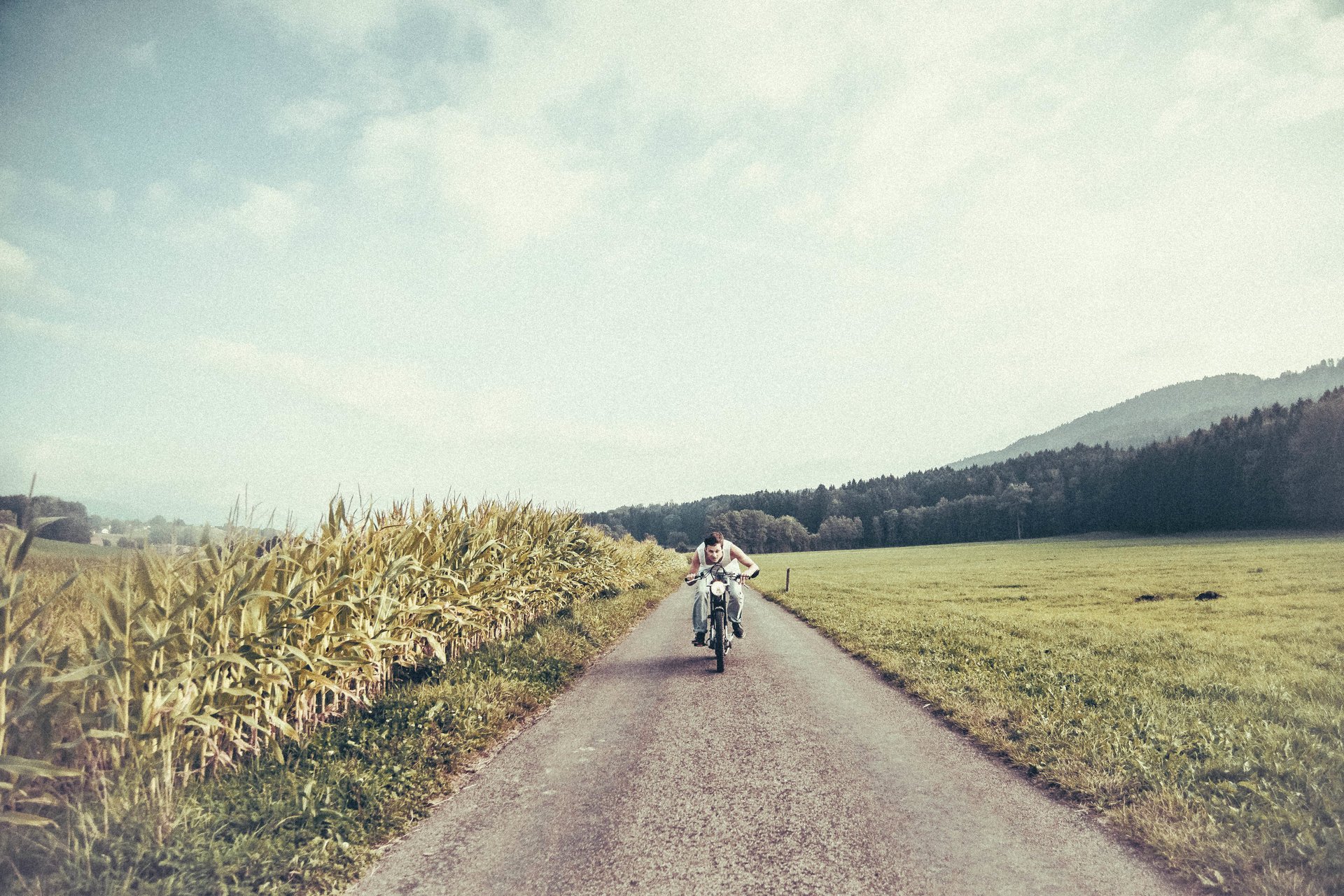 road men bike the field farm corn clouds sun