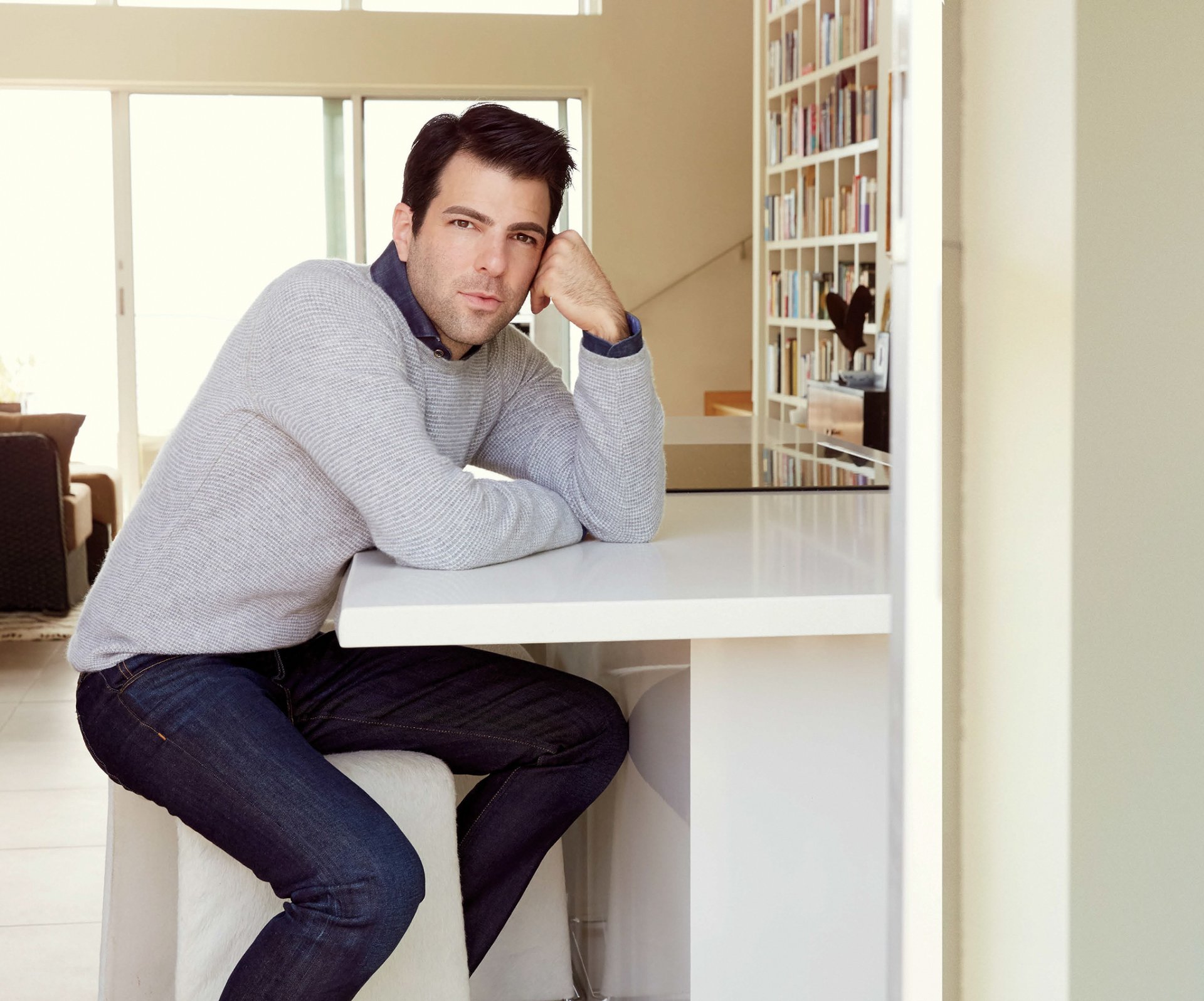 zachary quinto quinto attore seduto al tavolo maglione jeans servizio fotografico robert ascroft rivista hampton