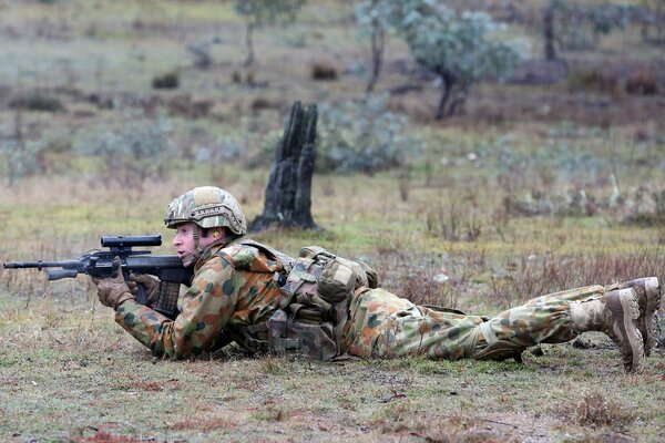 Soldat avec des armes en embuscade se trouve sur le ventre