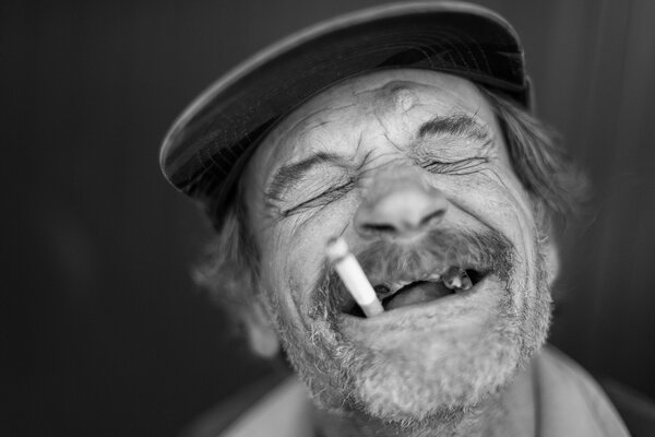 Hombre sin dientes con un cigarrillo en la boca