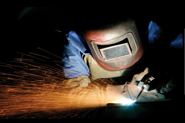 A steelworker in a protective mask doing his job