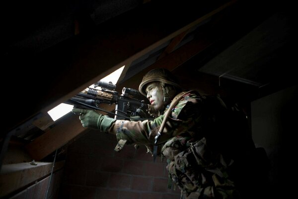 Soldat mit einer Waffe in der Hand auf dem Dachboden