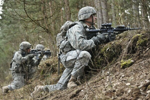 Soldiers with weapons in their hands among the trees