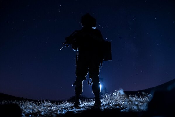 Soldado armado contra el cielo