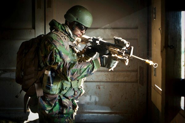 Ein Soldat mit einer Waffe zielt aus dem Gebäude