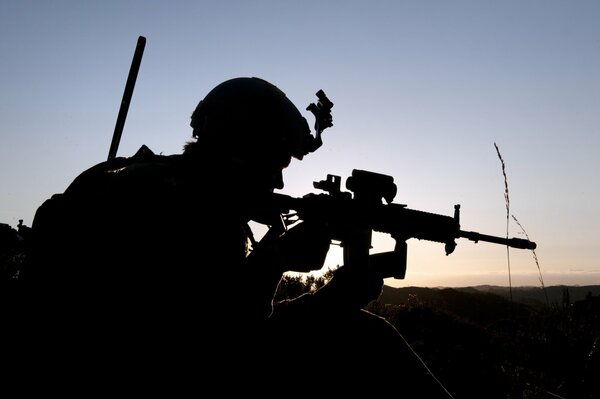 Evening twilight and a submachine gunner is visible looking for a target in the sight