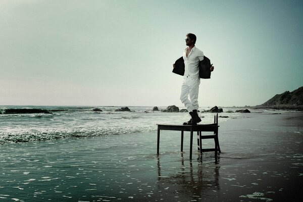 Chris Hemsworth on the table that stands on the beach