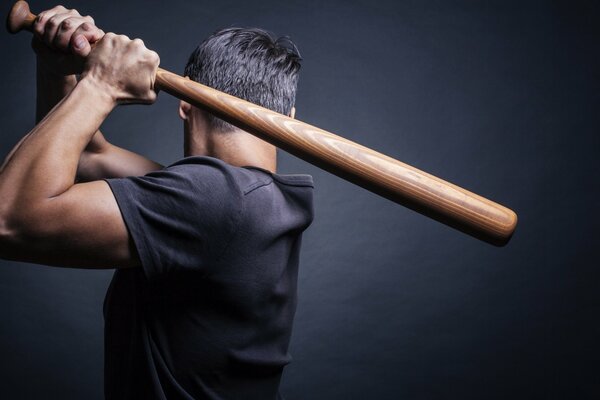 Hombre en camisa con bate de béisbol