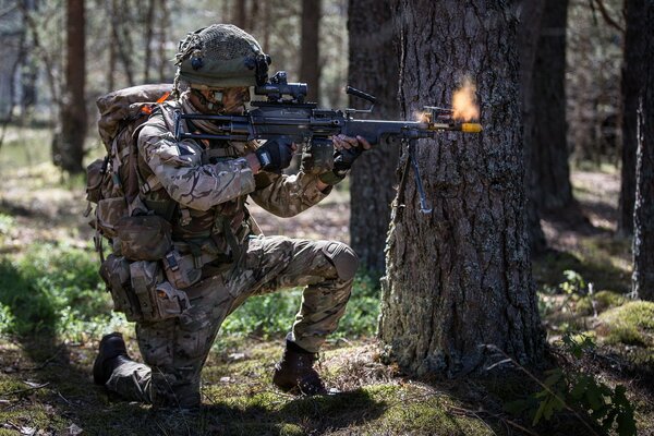 A soldier in the forest shoots at a target