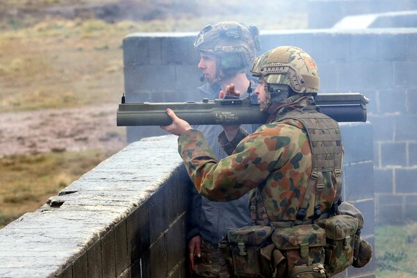 Ein Soldat mit einer großen Waffe auf der Schulter zielt darauf ab