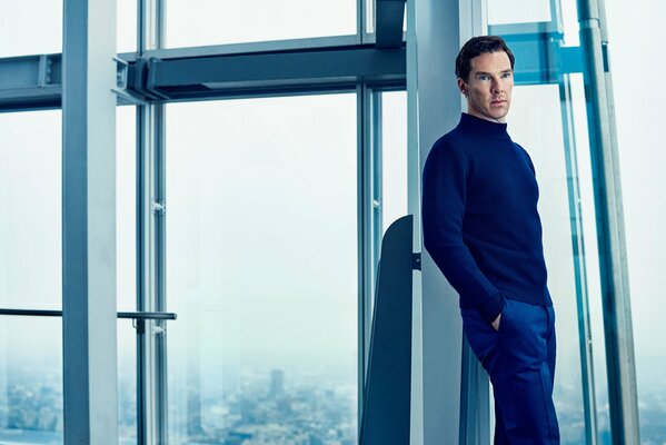 Benedict Cumberbatch con un suéter azul junto a la ventana