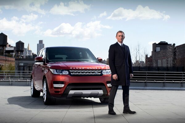 Daniel Craig als James Bond neben dem Auto