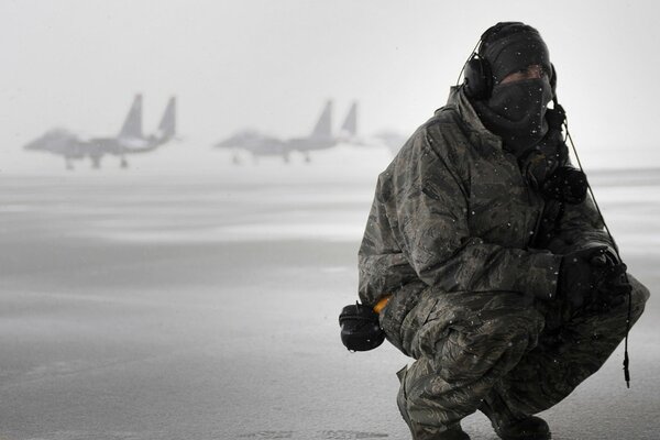 Hombre con uniforme en el campo de vuelo en invierno