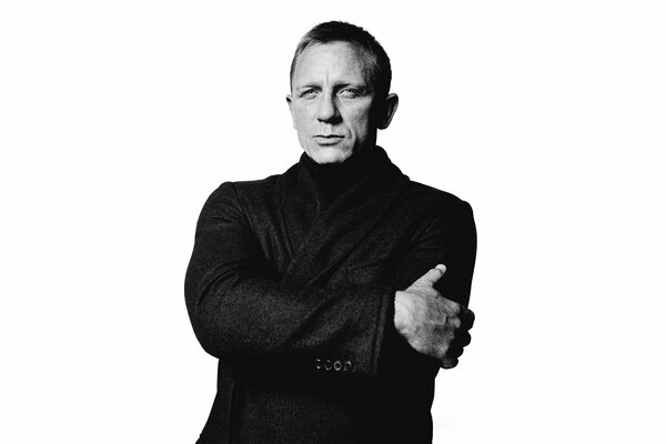 Acteur Daniel Craig en manteau noir sur fond blanc