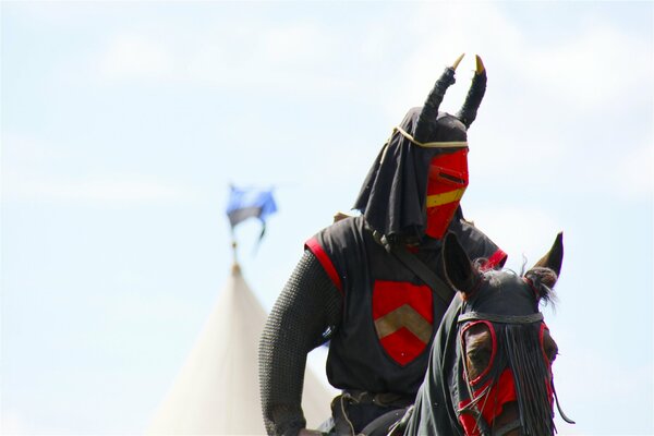 A warrior in black and red clothes on a horse