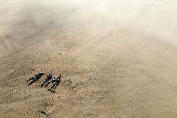 Soldiers are lying in the field aiming