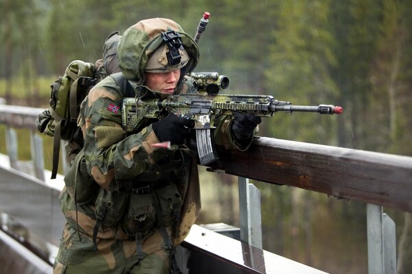 Ein Soldat zielt mit einer Waffe auf eine Brücke