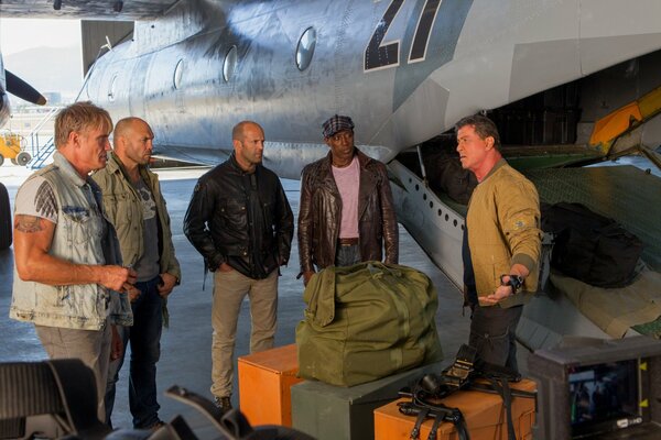 Actors from the movie The expendables 3 are standing by the plane