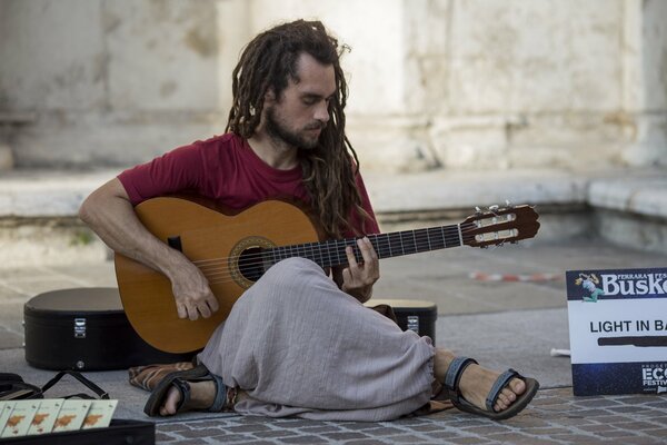 Músico callejero tocando la guitarra