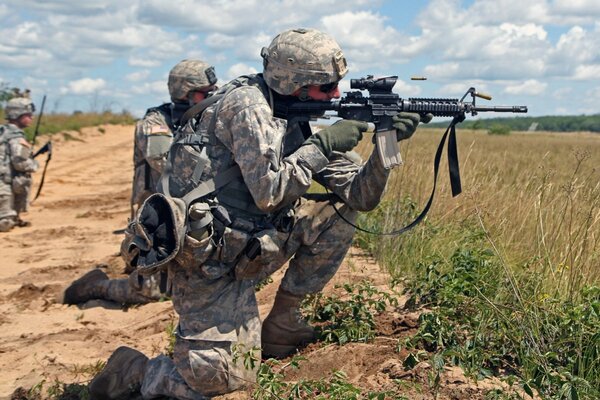 Three soldiers with weapons in the field