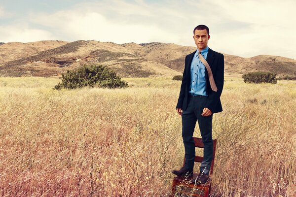 Photo shoot of an actor on a chair in a field