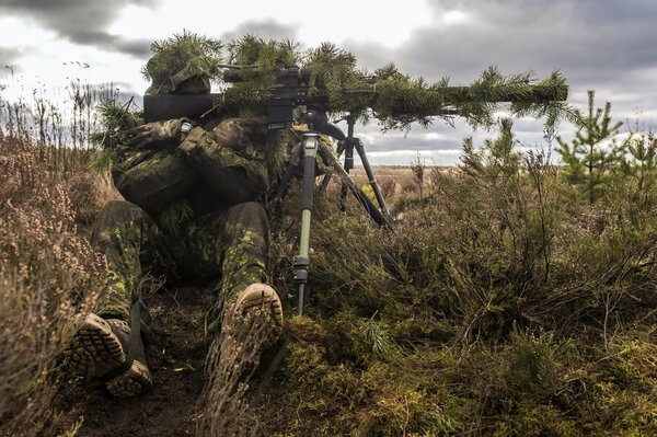 Soldat avec des armes dans un champ près de la Lituanie