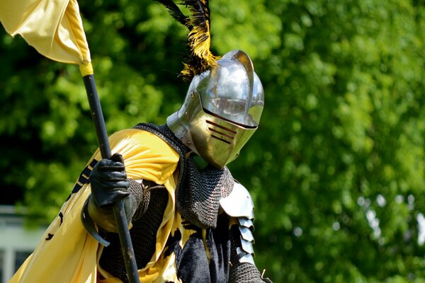 Chevalier en armure avec un manteau jaune et un casque avec des plumes