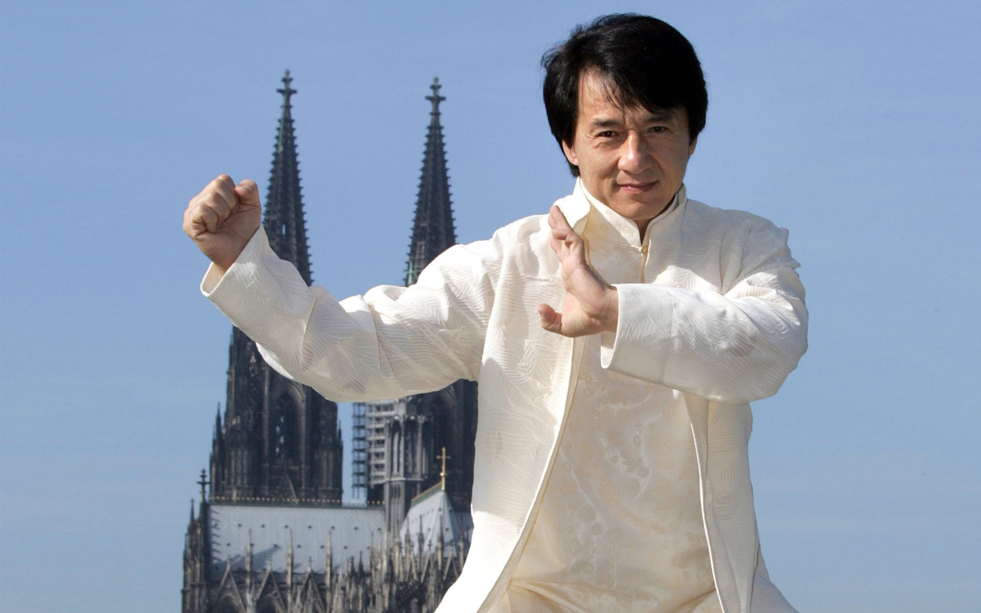 jackie chan schauspieler regisseur stuntman berühmtheit chinese freude lächeln stehen faust palme kung fu anzug weiß himmel