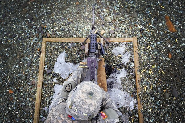 Żołnierz na ziemi z karabinem maszynowym M249