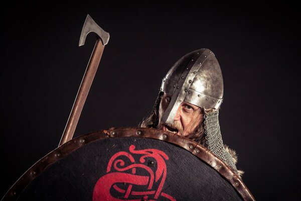 A warrior in a helmet with a shield and an axe