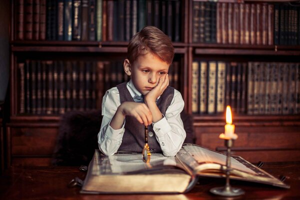 The boy is in with a book in the library building