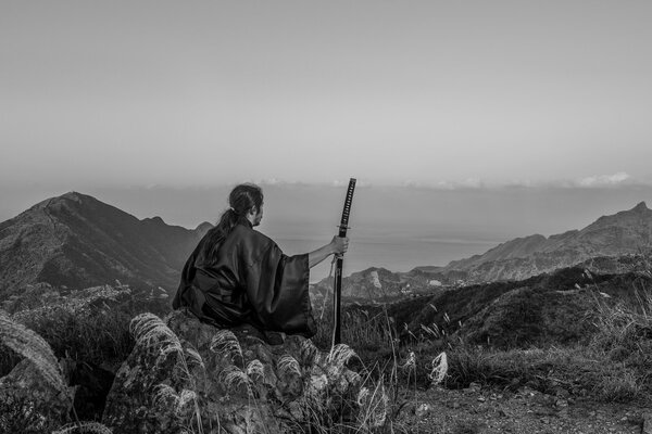 Samurai en la cima de una montaña con una espada