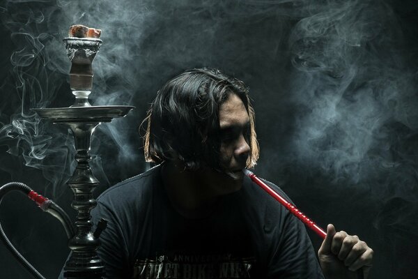 A man sits and smokes a hookah