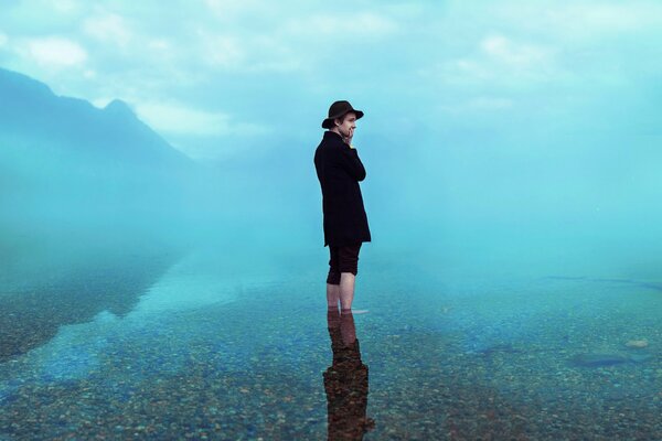 Uomo in cappello con riflessione in acqua