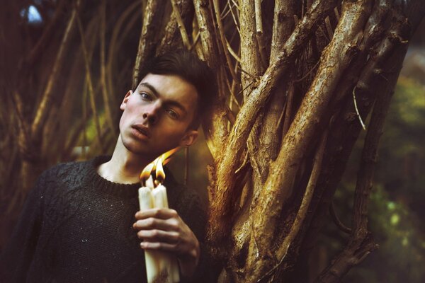 Photoshoot nel bosco di un ragazzo con le candele