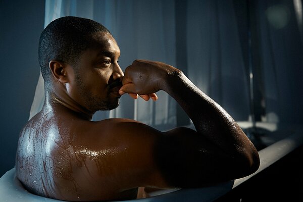 An African-American man in the bathroom is washing