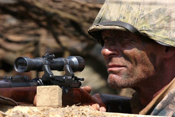 A sniper aiming with a rifle