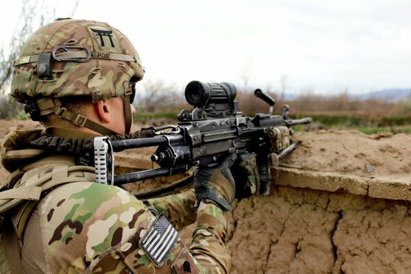 Soldado con armas sentado en un escondite