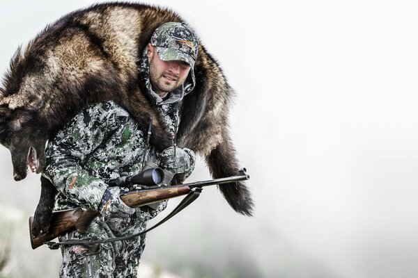 Mann mit Gewehr auf Winterjagd