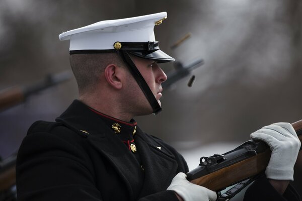 A soldier in a white cap with a gun