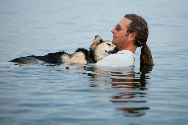 Mann und Hund in ruhigem Wasser