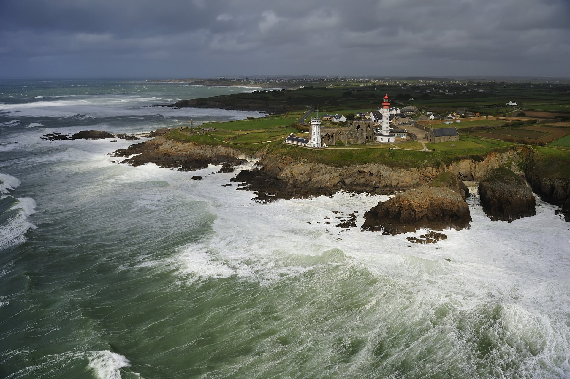 the city rocks lighthouse clouds the sky wave