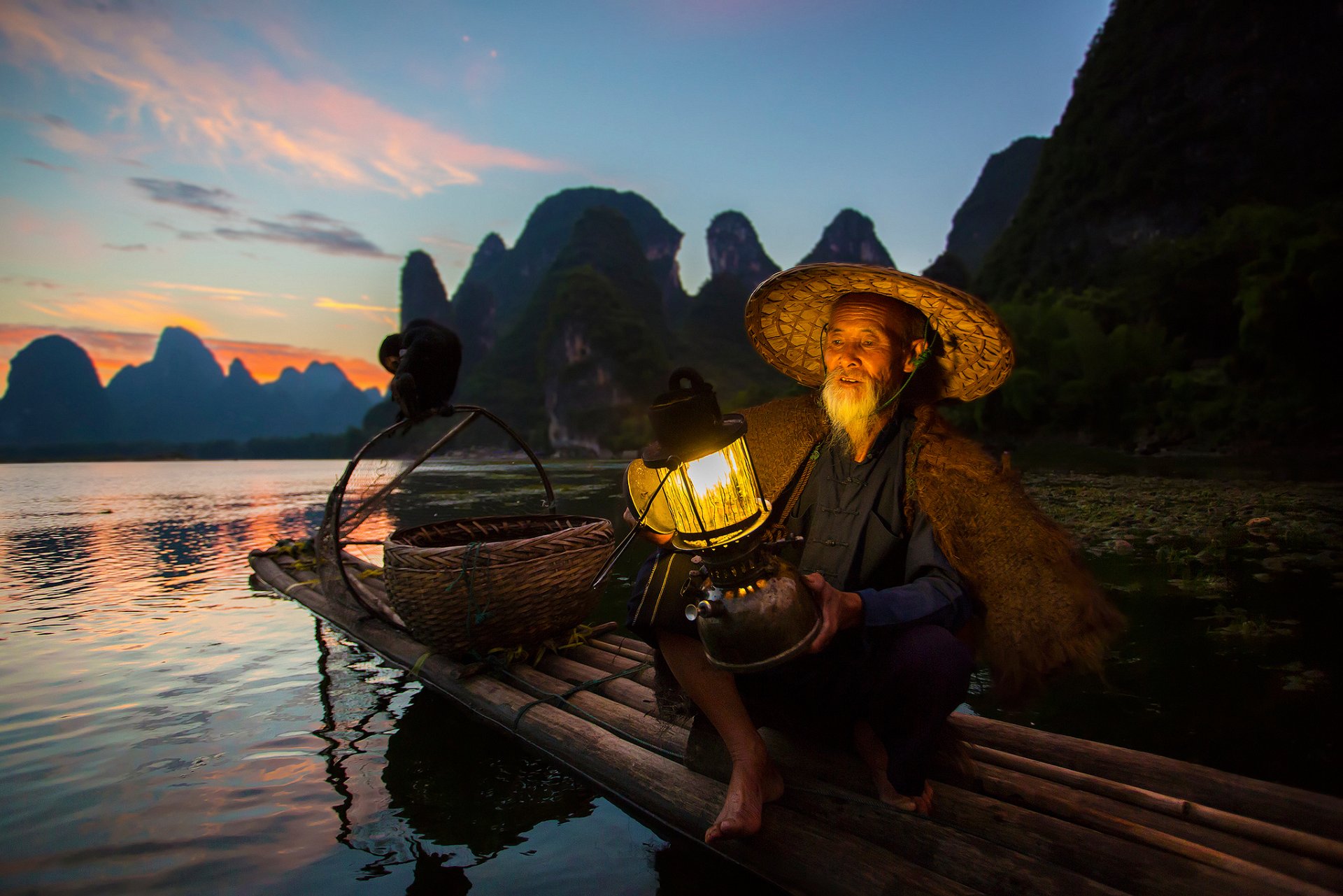 china region of guangxi zhuang river li river a fisherman boat light poultry cormorant