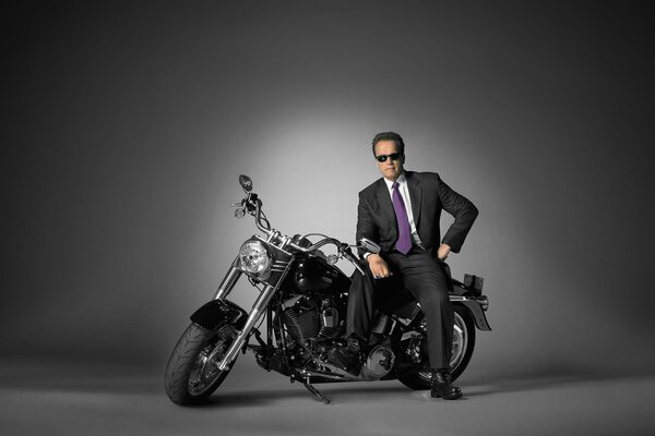 Arnold Schwarzenegger w garniturze na motocyklu