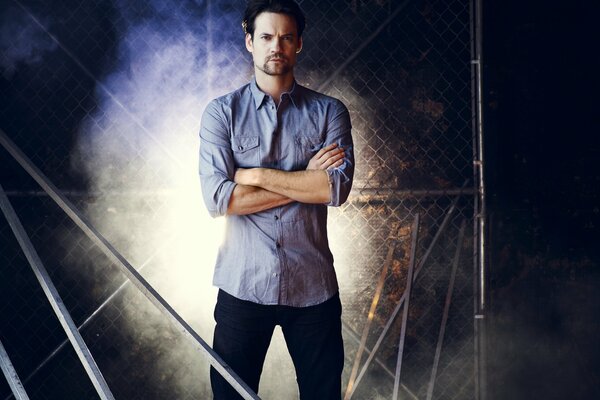 Shane West in a blue shirt on a grid background