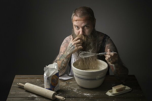 A man with a beard prepares dough