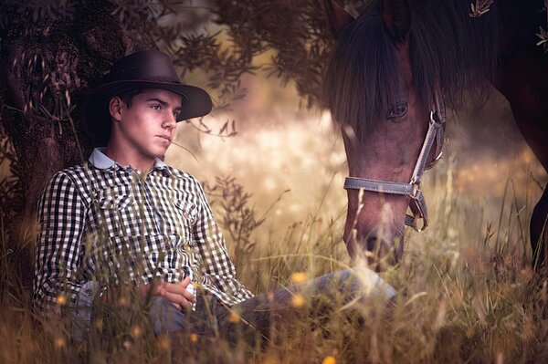 Un joven camina en un campo con un caballo